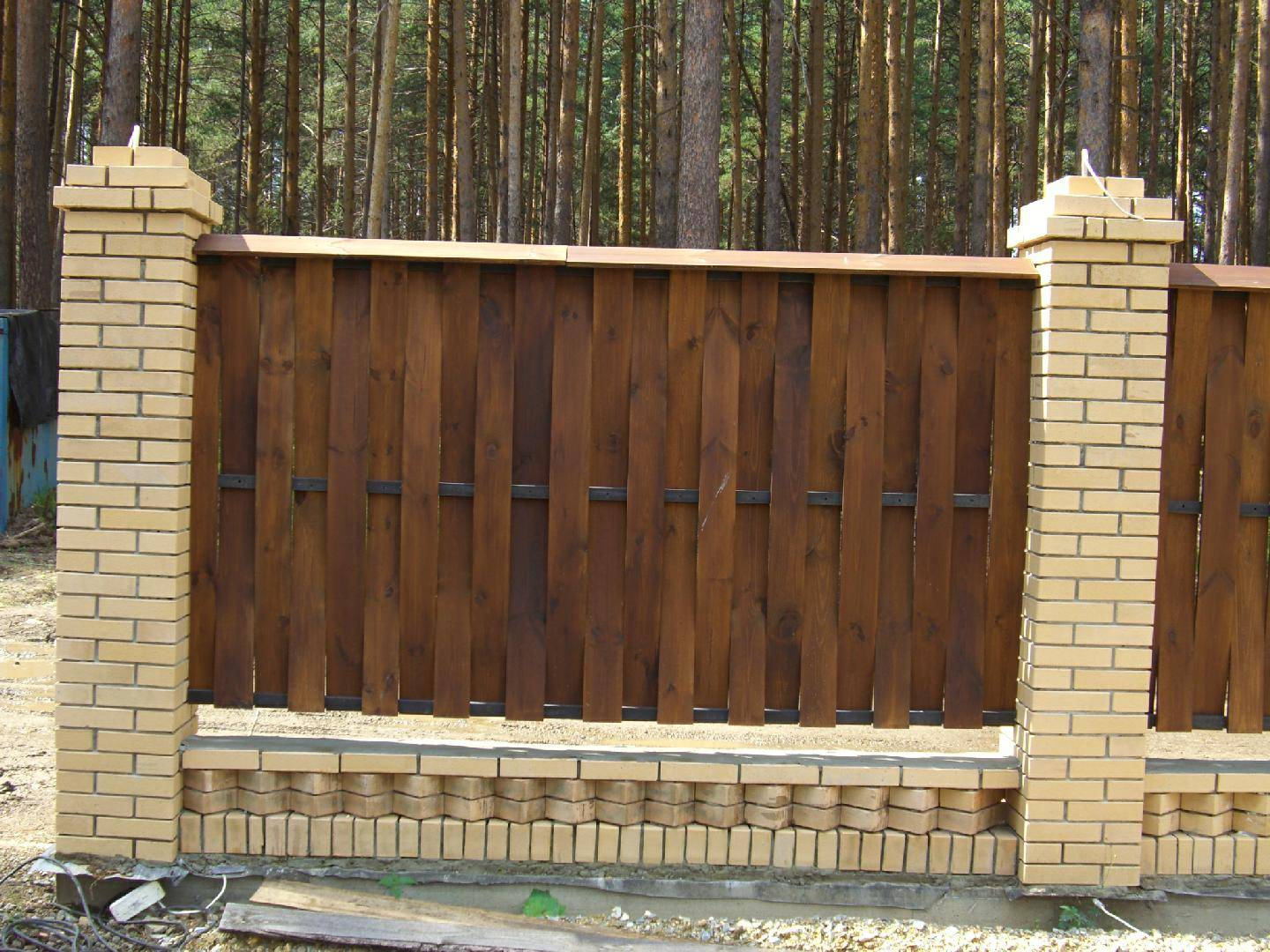 Деревянный забор с кирпичными колоннами
